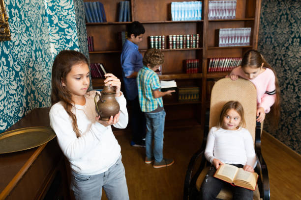 Group of young friends trying to find solution of quest in escape room with antique furnitures